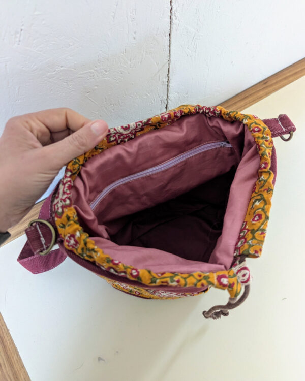 Intérieur du sac Évolution Nomade avec doublure rose, poche zippée et cordon de fermeture, patron sac bandoulière transformable.