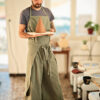 tablier de poterie vert olive en lin coton sur mannequin dans un atelier