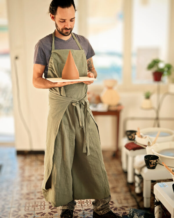 tablier de poterie vert olive en lin coton sur mannequin dans un atelier