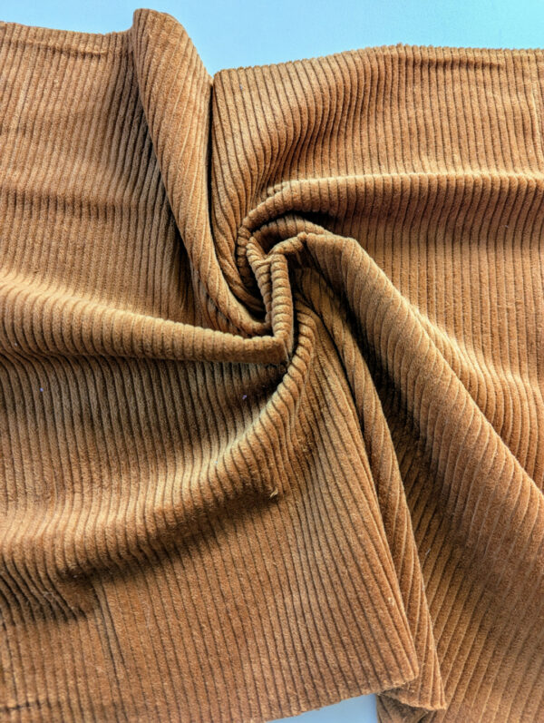 Gros plan sur le tissu velours côtelé marron, épais et chaleureux.