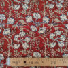 Gros plan sur les voiles de coton imprimés aux motifs graphiques et colorés d’inspiration indienne, feuille rouge