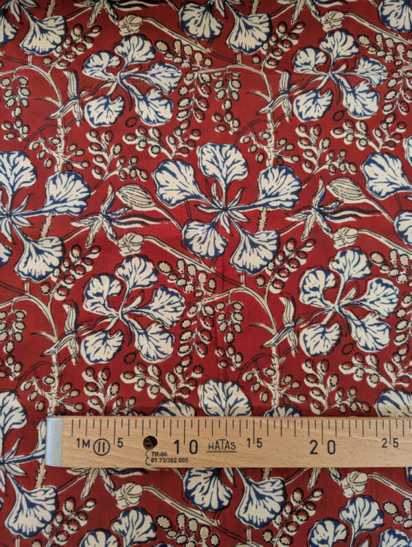 Gros plan sur les voiles de coton imprimés aux motifs graphiques et colorés d’inspiration indienne, feuille rouge