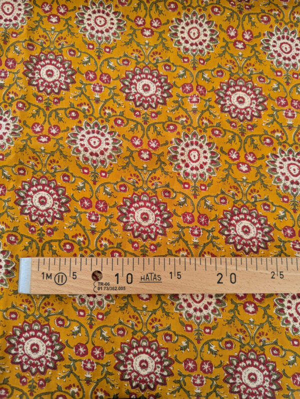 Gros plan sur les voiles de coton imprimés aux motifs graphiques et colorés d’inspiration indienne, fleur ocre