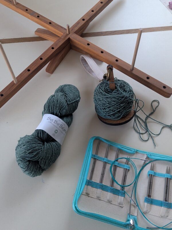 Dévidoir à laine en bois, support pour pelote et kit d’aiguilles circulaires interchangeables KnitPro Mindful posés sur une table, prêts pour préparer un écheveau de laine avant de tricoter. Accessoires de tricot pratiques pour enrouler la laine et réaliser des projets en aiguilles circulaires.