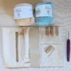 Contenu de la box crochet pour réaliser une trousse à bijoux nomade avec coton bio, doublure cousue, étiquette en bois, crochet et aiguille à laine.