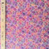 Tissu coton Filena à fleurs effet peinture, dans des nuances de rose fuchsia, violet, rouge et orange avec feuillages brun doré.