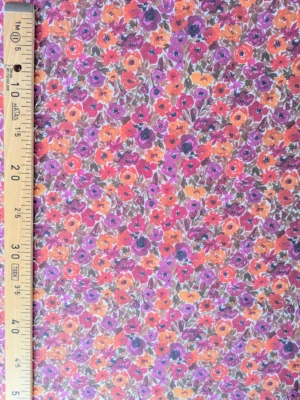 Tissu coton Filena à fleurs effet peinture, dans des nuances de rose fuchsia, violet, rouge et orange avec feuillages brun doré.
