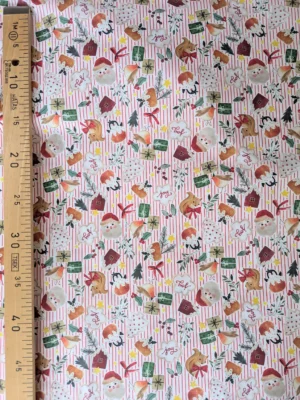 Tissu coton Noël Bredle à rayures rouges et blanches, imprimé de biscuits, écureuils, cadeaux, sapins et personnages festifs.