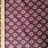 Velours milleraies Hoko à fleurs stylisées écrues et orange, feuillages bordeaux sur fond foncé, motif floral rétro.